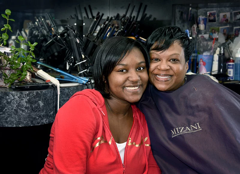 Two of three generations of clients, Jojo, 16 (left) and her mother, Tiana, are freshly coiffed after their Saturday morning appointments with Rosalyn Redwine, salon owner. Tiana’s mother (and Jordyn’s grandmother) is also a longtime client. Photo by Sonya Doctorian.