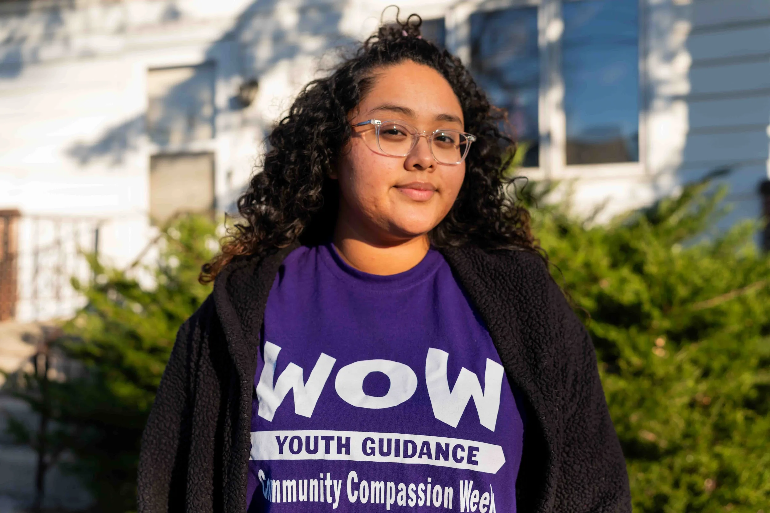 Brown & Black girls support Working on Womanhood: portrait of young woman with long, dark hair, standing outside.