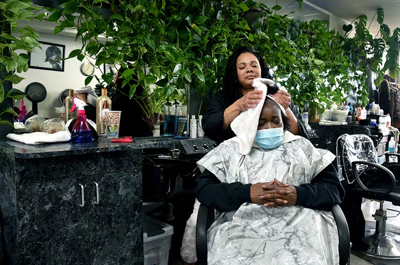 Kimyatta Dudley towels off Beverly Bunton’s hair after a shampoo. Kimyatta has been a hair stylist at Winning Coiffures for 23 years. Beverly has been coming to the salon on East Colfax Avenue for 15 years. Photo by Sonya Doctorian.