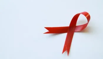 Close-up view of red ribbon on white background showing HIV disease symbol with copy space. Awareness concept. healthcare concept. World AIDS Day.