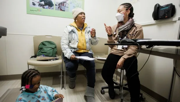 Dr. Javay Ross, right, a pediatrician and co-founder of the BLOOM: Black Baby Equity Clinic, talks with Ersula Capers of Oakland as Ross conducts a health screening on Capers' granddaughter Christina Dozier, 2, on Friday, Jan. 19, 2024, at UCSF Benioff Children's Hospital's Claremont Clinic in Oakland, Calif. (Dai Sugano/Bay Area News Group)