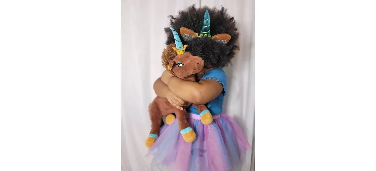 Child holding Afro Unicorn Plush Animal