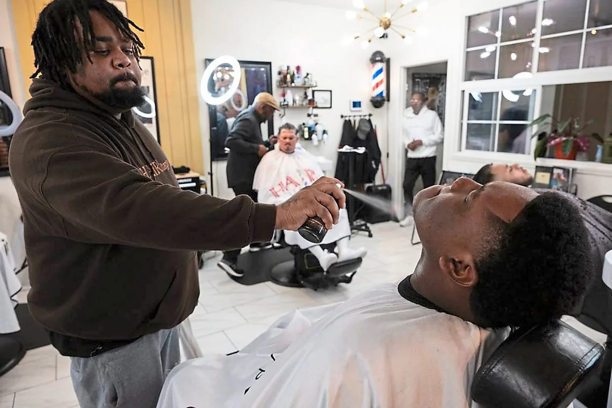 Wayne ‘Paper Kutz’ Threets (left) adding the final touches to Grant High School student Amiere Lewis’ shave.