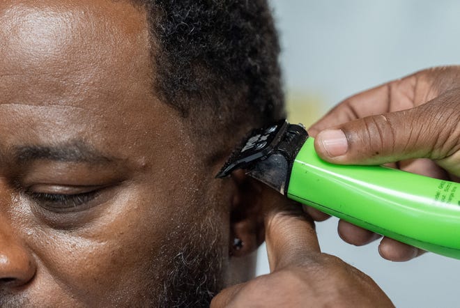 J. Divine Alexander cuts Eddie Dyre’s hair on Sunday, June 23, 2024 at The LAB Louisville, his barbershop in Louisville, Ky. Alexander, 50, is a participant in The Confess Project, a national mental health effort that trains barbers and stylists to be mental health advocates in Black communities, in which a longstanding stigma often surrounds mental health care. Such programs tap into the open conversation spaces that barbershops and salons create to address underlying issues and connect customers with resources when necessary.