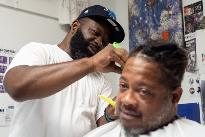 J. Divine Alexander cuts LaRon Williams' hair on Sunday, June 23, 2024, at The LAB Louisville, his barbershop in Louisville, Ky. Alexander, 50, is a participant in The Confess Project, a national mental health effort that trains barbers and stylists to be mental health advocates in Black communities, in which a longstanding stigma often surrounds mental health care. Such programs tap into the open conversation spaces that barbershops and salons create to address underlying issues and connect customers with resources when necessary.