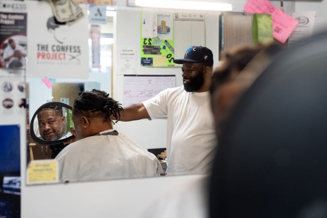 J. Divine Alexander cuts LaRon Williams' hair on Sunday, June 23, 2024, at his barbershop in Louisville, Ky. Alexander, 50, is a participant in The Confess Project, a national mental health effort that trains barbers and stylists to be mental health advocates in Black communities, in which a longstanding stigma often surrounds mental health care. Such programs tap into the open conversation spaces that barbershops and salons create to address underlying issues and connect customers with resources when necessary.