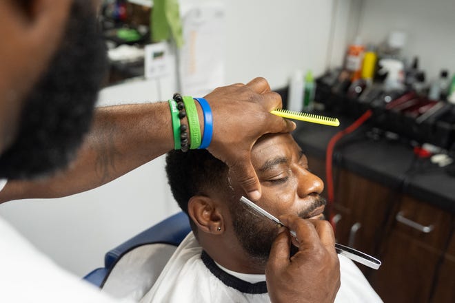 J. Divine Alexander cuts Eddie Dyre’s hair on Sunday, June 23, 2024, at his barbershop in Louisville, Ky. Alexander, 50, is a participant in The Confess Project, a national mental health effort that trains barbers and stylists to be mental health advocates in Black communities, in which a longstanding stigma often surrounds mental health care. Such programs tap into the open conversation spaces that barbershops and salons create to address underlying issues and connect customers with resources when necessary.