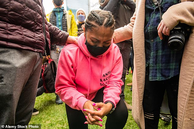 A mourner takes the knee in 2021 after a police officer was convicted of Mr Floyd's murder