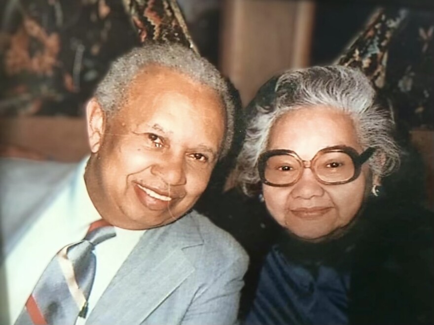 An elderly couple smiles for the camera. 