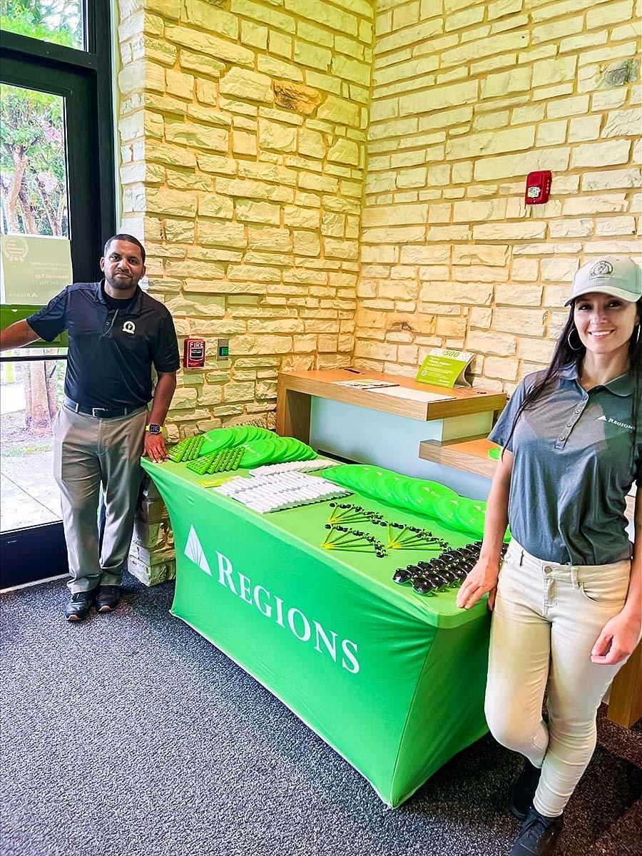 Two people stood either side of a Regions event table 