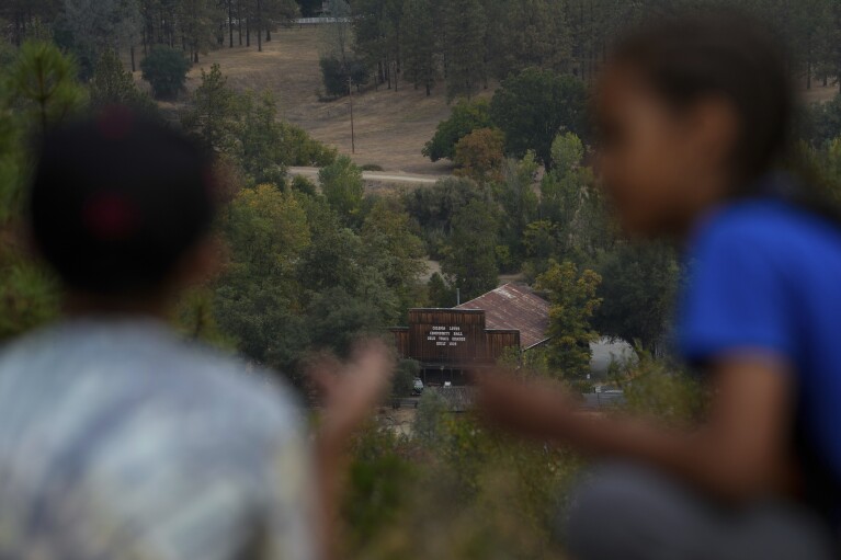 The present-day Grange Hall, center, is seen as school children, foreground, visit Marshall Gold Discovery State Historic Park, Tuesday, Oct. 10, 2023, in Coloma, Calif. (AP Photo/Godofredo A. Vásquez)