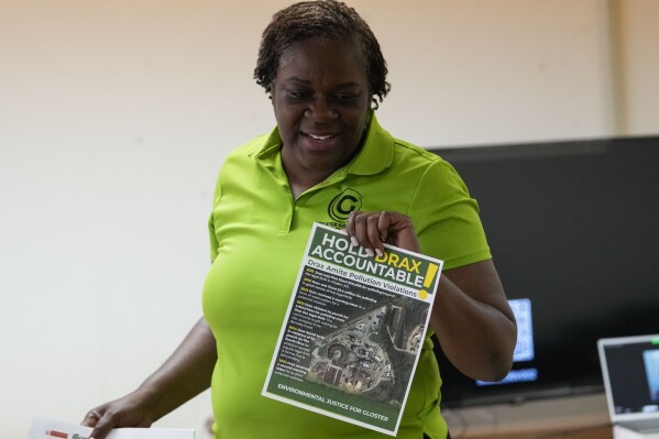 Krystal Martin, a Gloster native, shows pamphlets during a community meeting she organized regarding health complaints against the Drax facility in Gloster, Miss., Thursday, May 2, 2024. (AP Photo/Gerald Herbert)