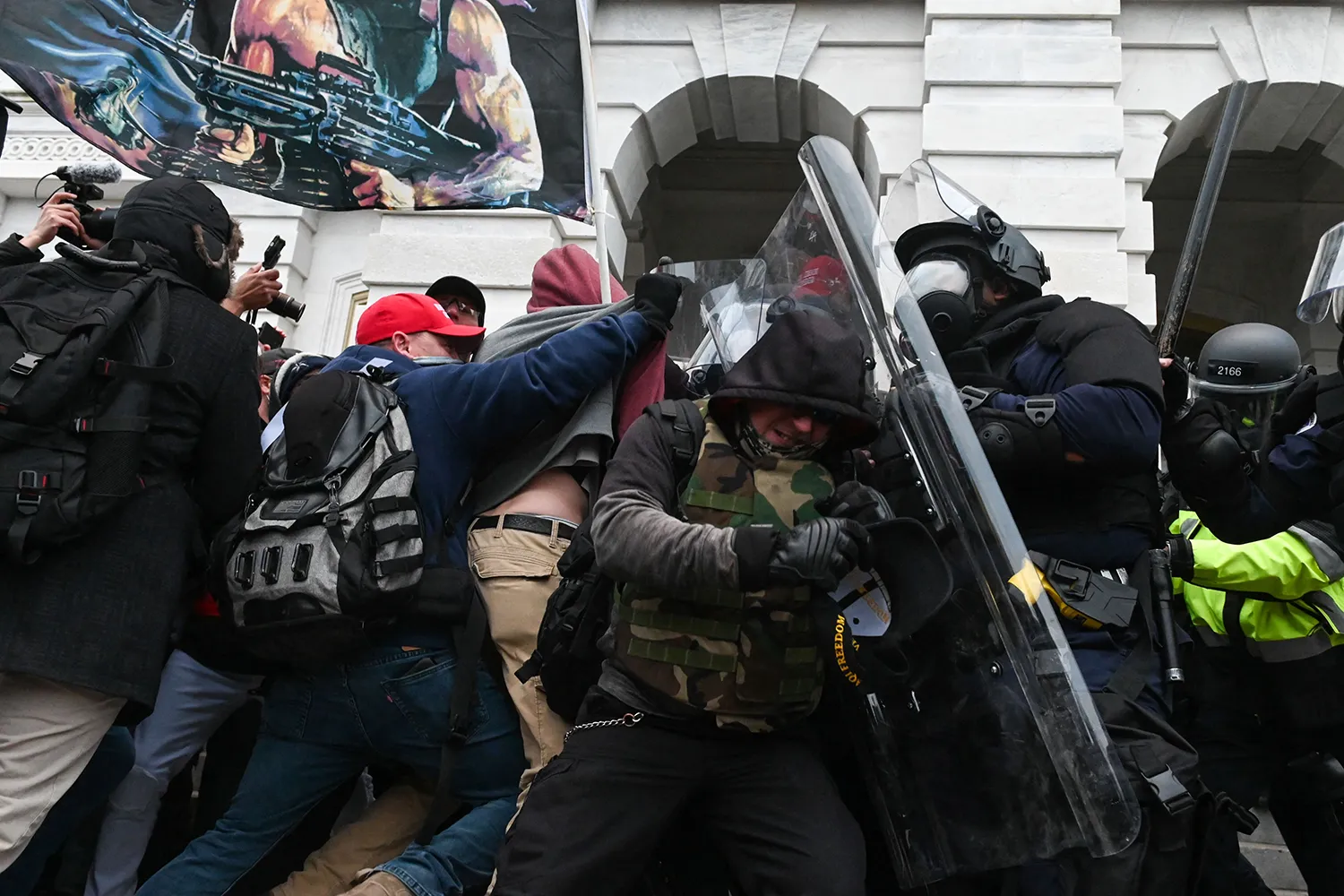 Riot police clash with protestors in front of the Capitol building.