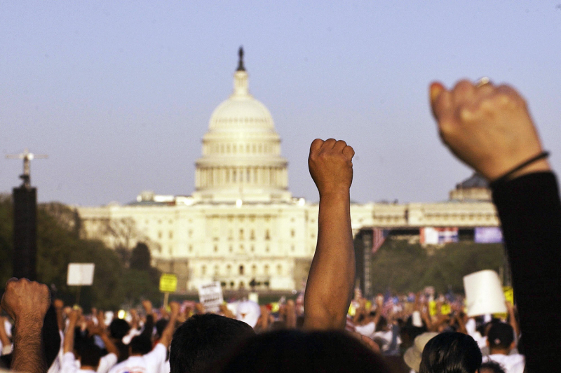 Immigration protestors raise their fists during an immigration rally on the National Mall before the US Capitol on April 10, 2006 in Washington, DC.