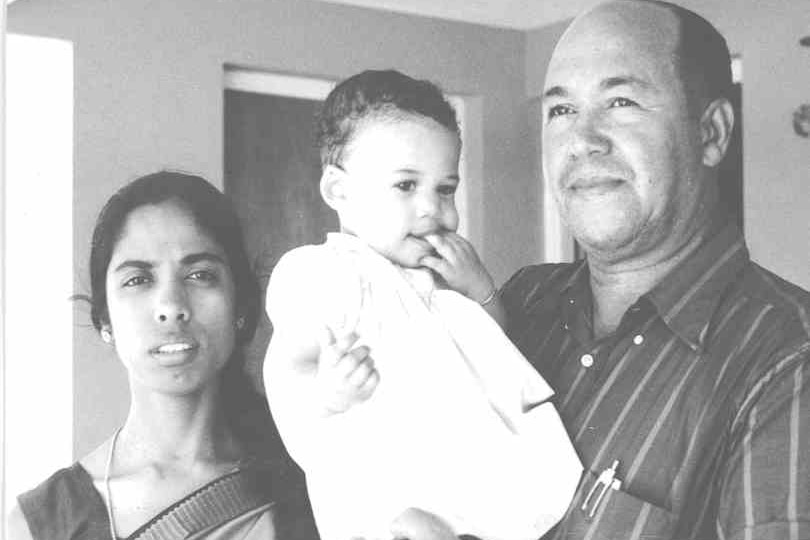 A black and white photo of Kamala Harris as a baby being held by her parents