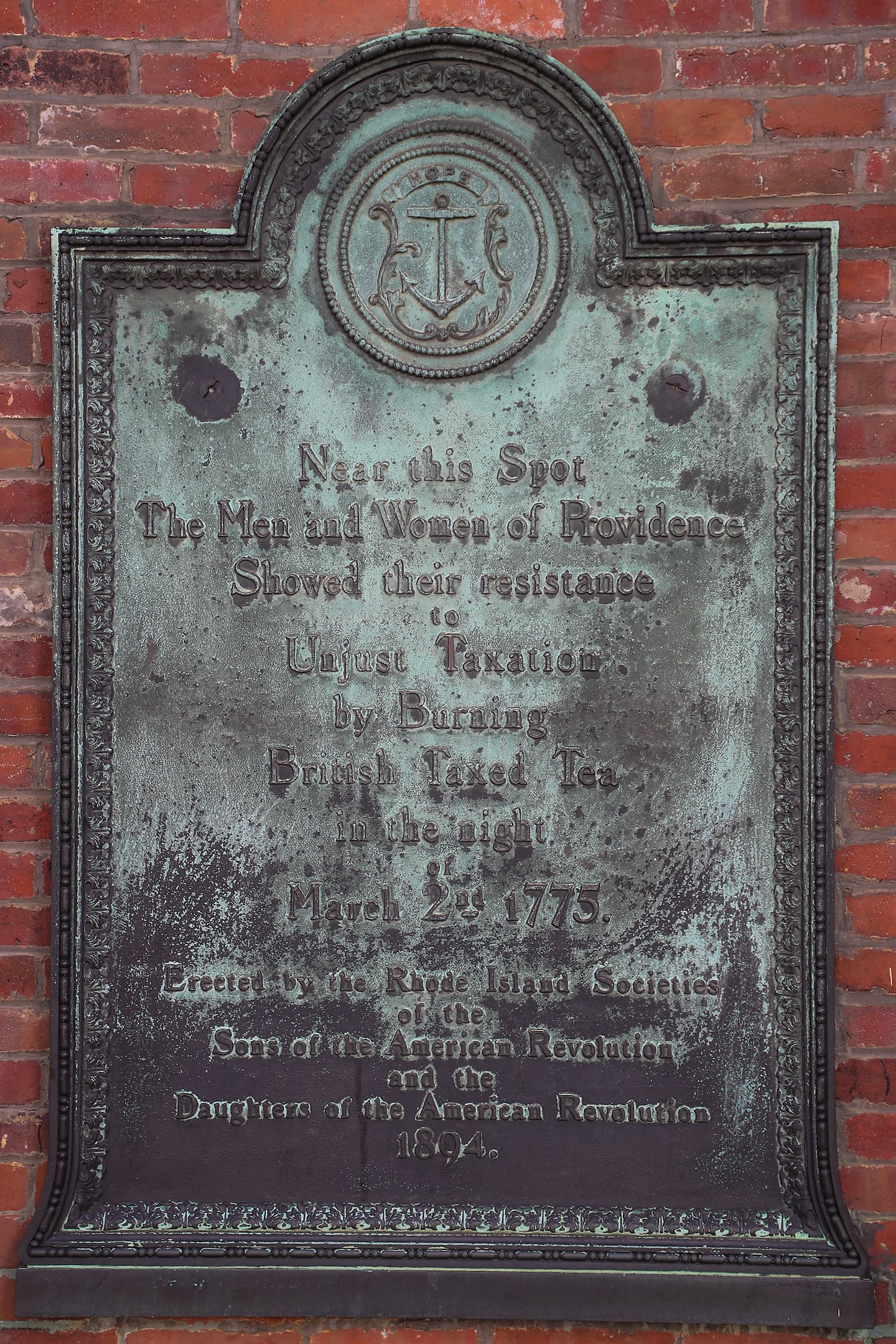 A detail shot of a plaque on the left side of the front door of the Market House in Market Square in Providence, R.I.