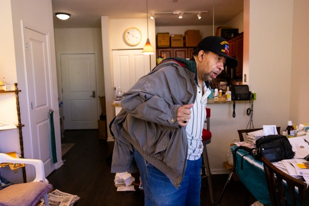 Kenneth Wideman puts on his jacket before leaving his apartment in Evanston on April 27, 2023. (Eileen T. Meslar/Chicago Tribune)