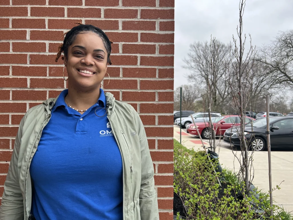 DeShae Jackson, a Dayton-based doula, poses for a portrait in front of a brick wall