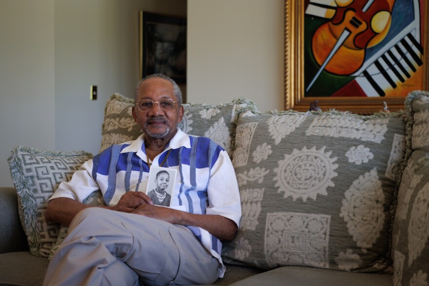 James Gallagher poses for a portrait in his home, holding a photo of when he was ten years old in St. Louis County on Friday, September 20, 2024.