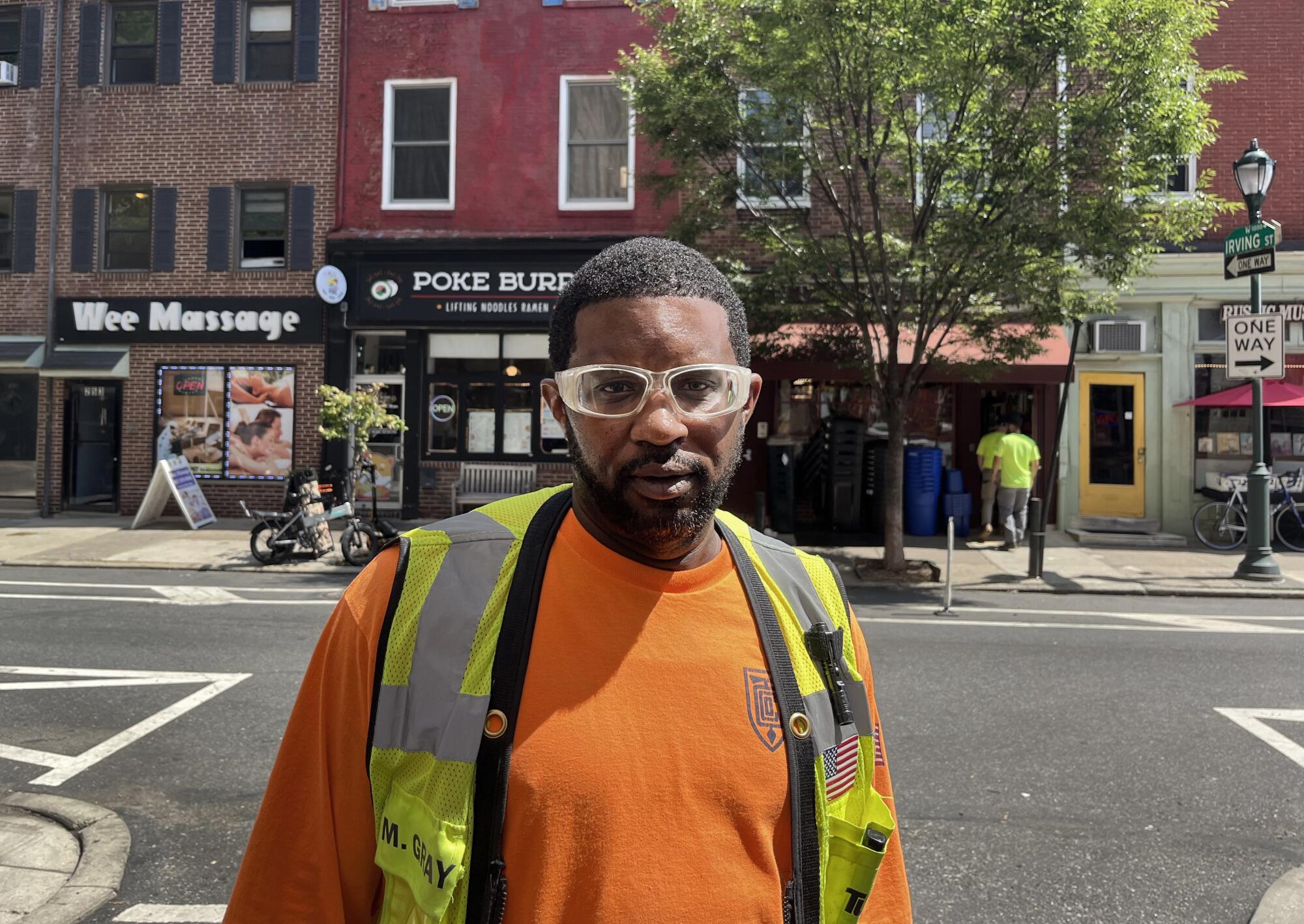 Mike Gray wearing an orange work shirt, neon safety vest and goggles