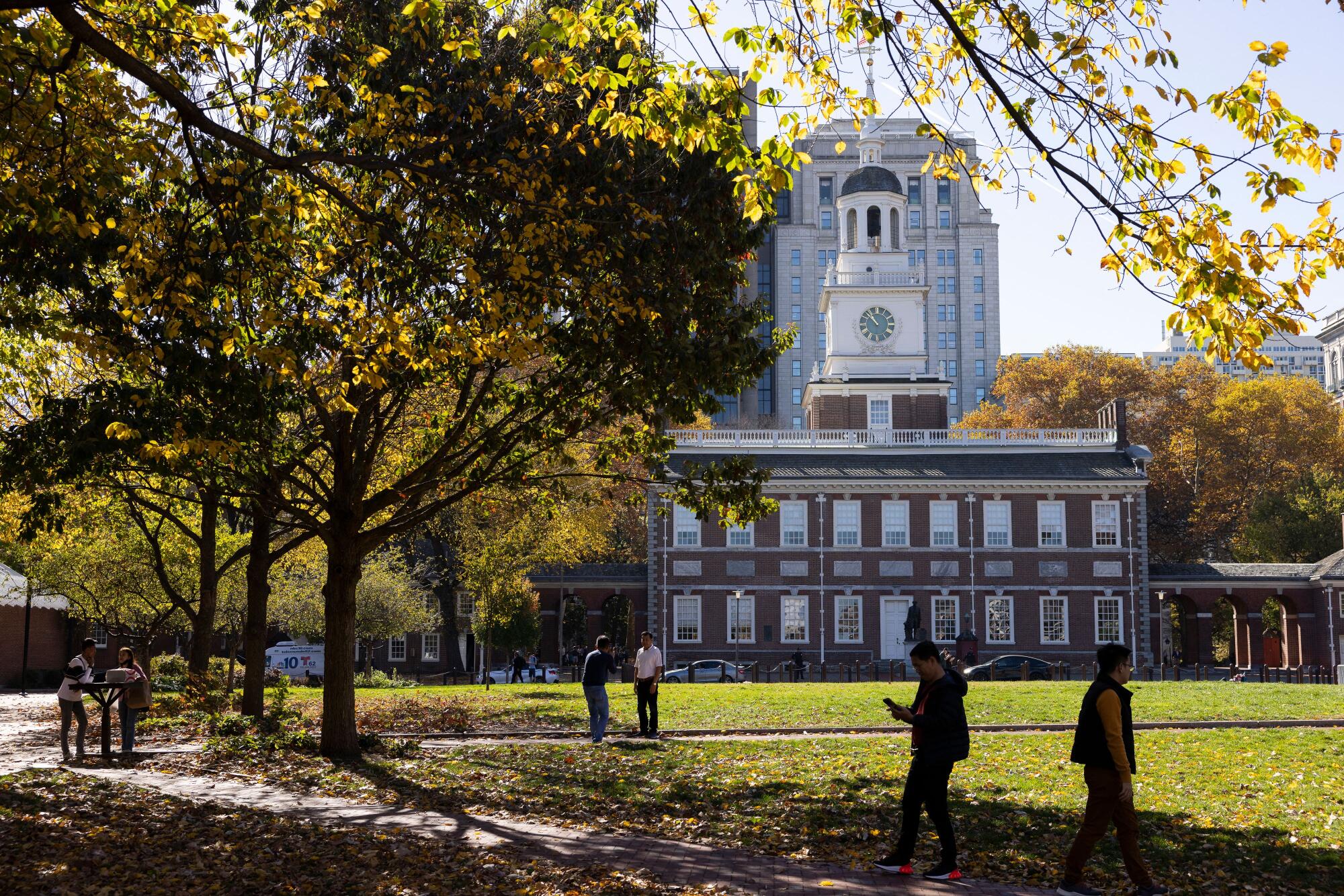 Parkgoers under the shade of a tree outside Independence Hall in Philadelphia