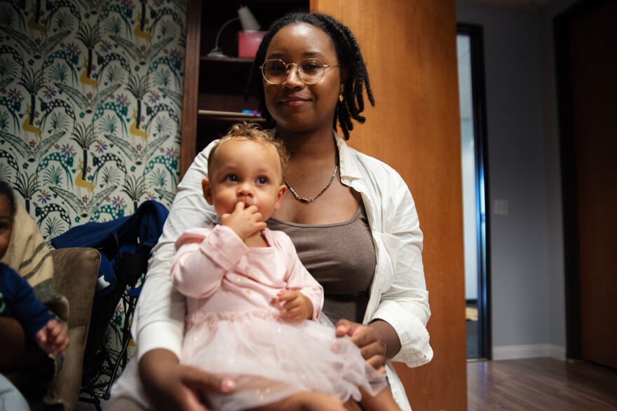 Chaya Richie, an African American mother, holds her daughter on her lap in Oceanside, Calif. Sept. 18, 2024. 