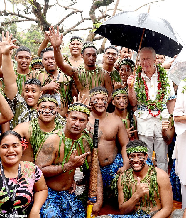 King Charles III and Queen Camilla pose with a local traditional cricket team members during his Samoa Cultural Village visit today