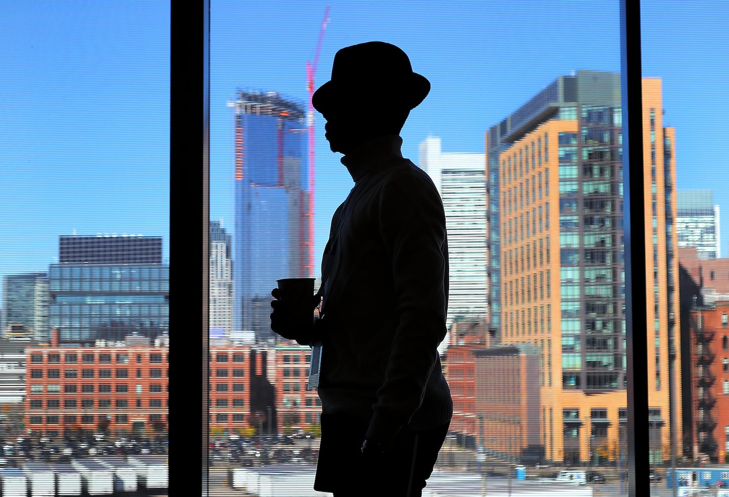 The annual Mass Black Expo’s second day took place at the BCEC. Carl-Henry Auguste, an insurance agent from Brockton, took a coffee break as he looked over the Boston skyline. 