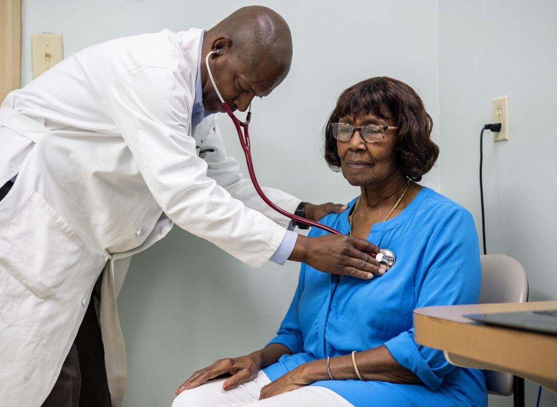 Morris Brown, a primary care physician, listens to Sarah McCutcheon’s heartbeat in the exam room at his medical office in Kingstree, South Carolina, which sits in a region that suffers from health care provider shortages and high rates of chronic diseases.