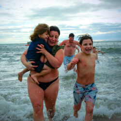 A mother and her children race back to the beach after participating in the 2025 New Year’s Day Polar Bear Plunge on Coney Island. Photo by Beth Eisgrau-Heller