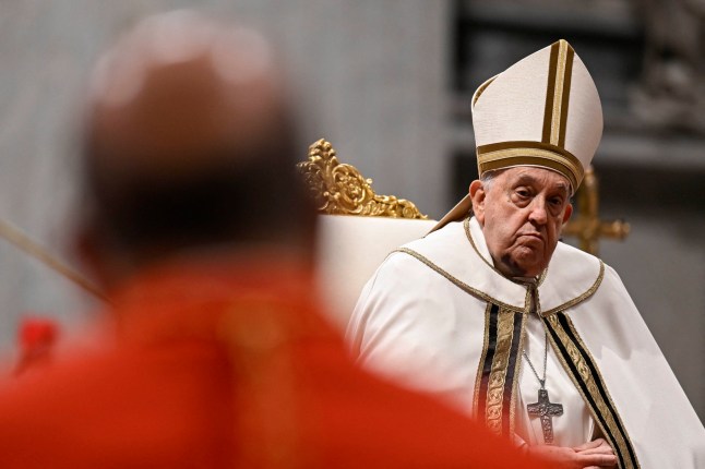 This handout photo taken and relased by the Vatican Media on December 7, 2024 shows Pope Francis during an Ordinary Public Consistory for the creation of new cardinals, at St. Peter's Basilica in the Vatican, on December 7, 2024. On December 7, Pope Francis will create 21 new cardinals from five continents, including bishops from Algiers, Tehran, Tokyo and Abidjan, many of whom may one day help choose his successor. In the tenth such consistory since he became pope in 2013, Francis, 87, is seeking again to shape the upper echelons of the Catholic Church in his image, and consolidate his legacy as the leader of a more inclusive and global institution. (Photo by Handout / VATICAN MEDIA / AFP) / RESTRICTED TO EDITORIAL USE - MANDATORY CREDIT 