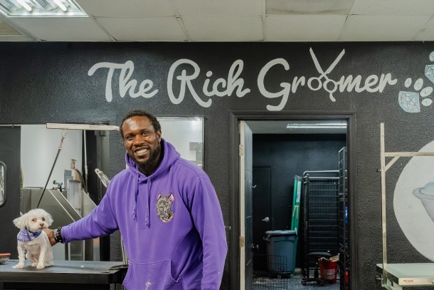 Cam Mbewa, founder of the Rich Groomer, poses with a dog after its grooming session. Amayah Harrison-Bryant, OBSERVER